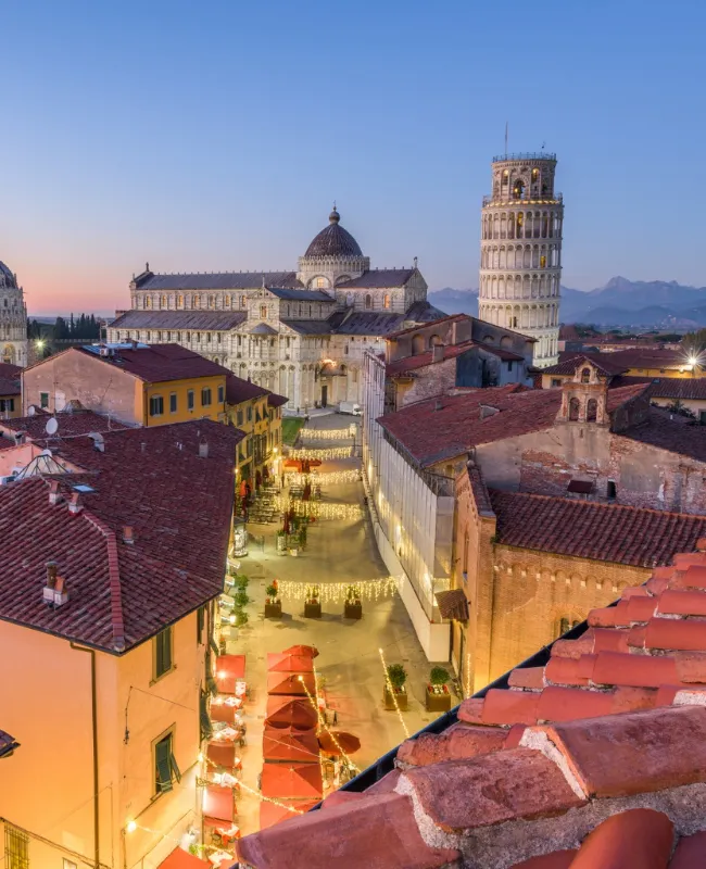 The majestic Campo dei Miracoli in Pisa, home to the famous Leaning Tower and other historical monuments surrounded by lush green fields.